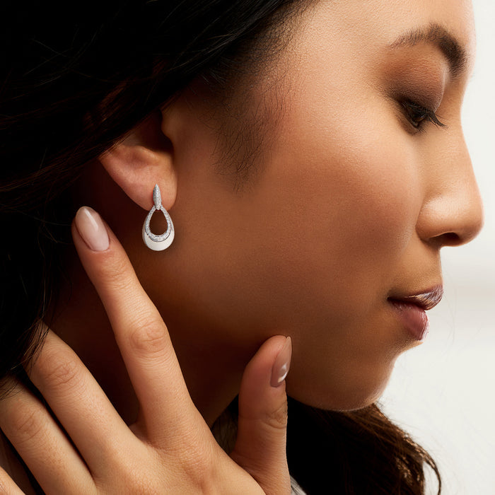 Sterling silver teardrop diamond drop earrings worn on ear
