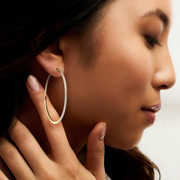 Diamond hoop earring in 18kt gold over sterling, shown on a model