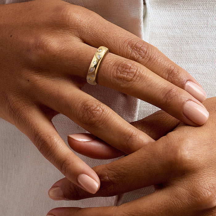 Scattered diamond ring in 18kt gold over sterling worn on hand, rounded band with stones