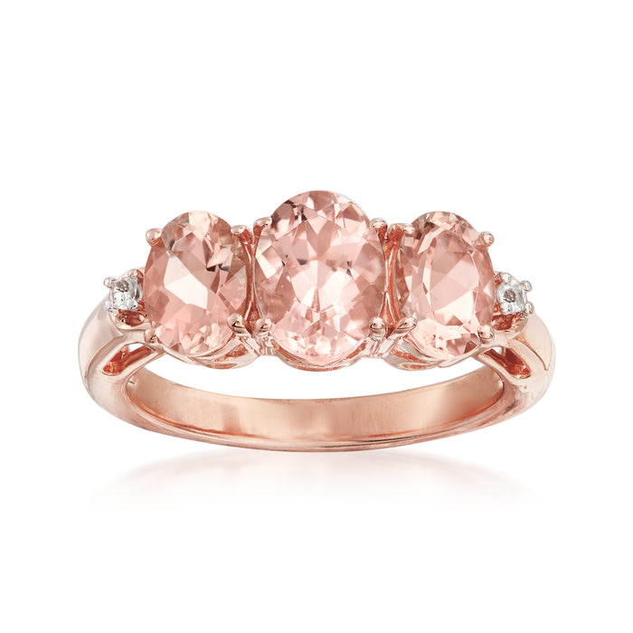 Rose gold morganite ring with three oval pink gemstones and small white accents