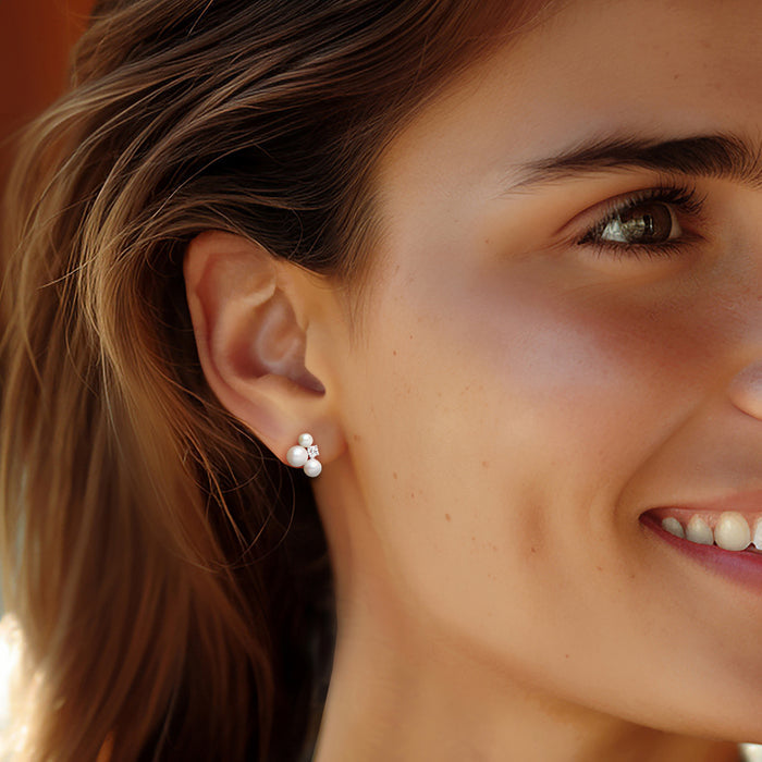 Cultured pearl and lab-grown diamond stud earrings on a model, sterling silver posts