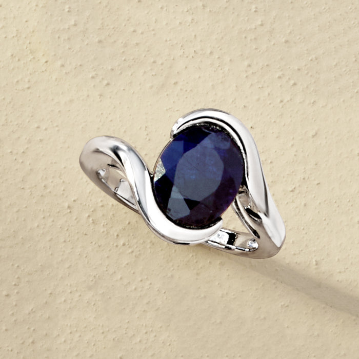 Sterling silver ring with deep blue oval sapphire and curved claw-like prongs