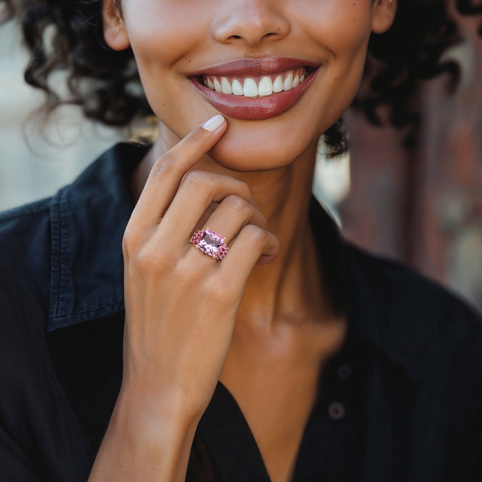 Amethyst and pink gemstone ring with cushion-cut center and rose gold band on finger