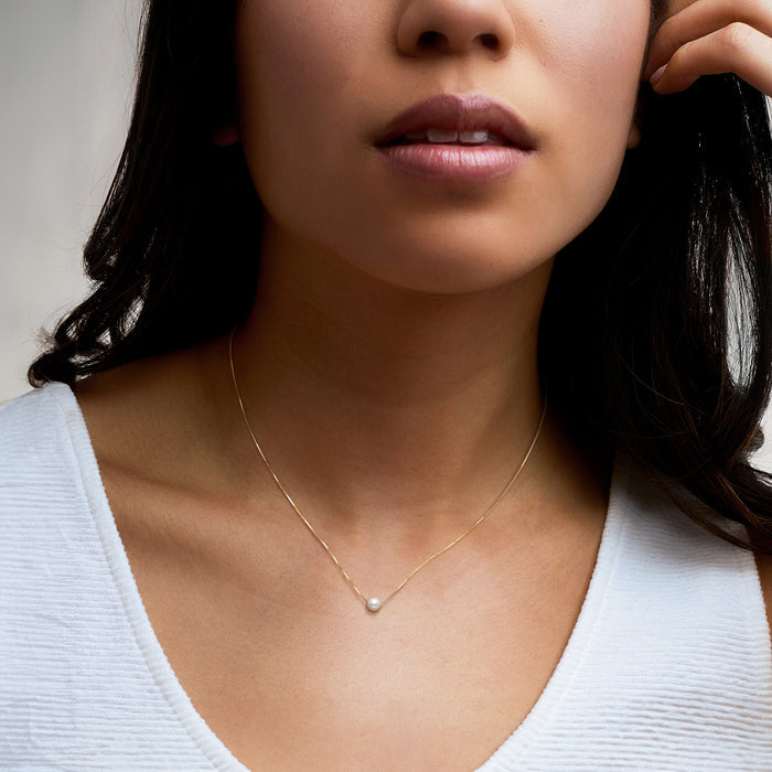 Cultured pearl pendant necklace on model with 14kt yellow gold chain