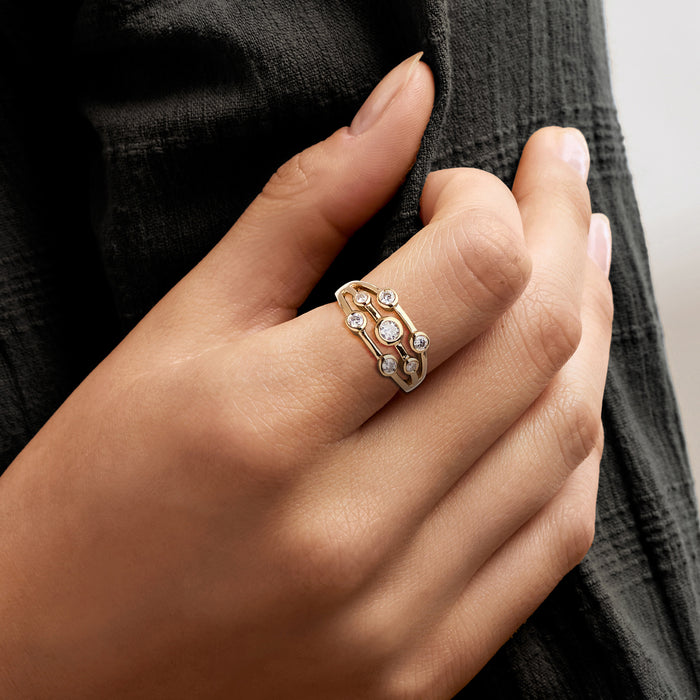 Gold diamond ring on hand, multi-row bezel-set round stones in openwork bezel settings