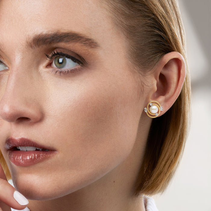 Cultured pearl swirl stud earring with diamond accents shown on ear in gold tone