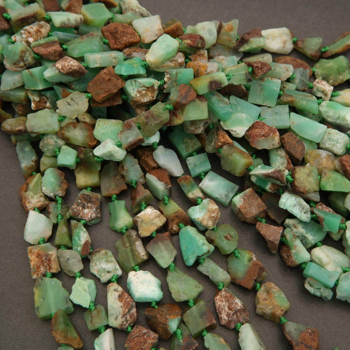 Necklace made of green and brown stone beads on a brown background