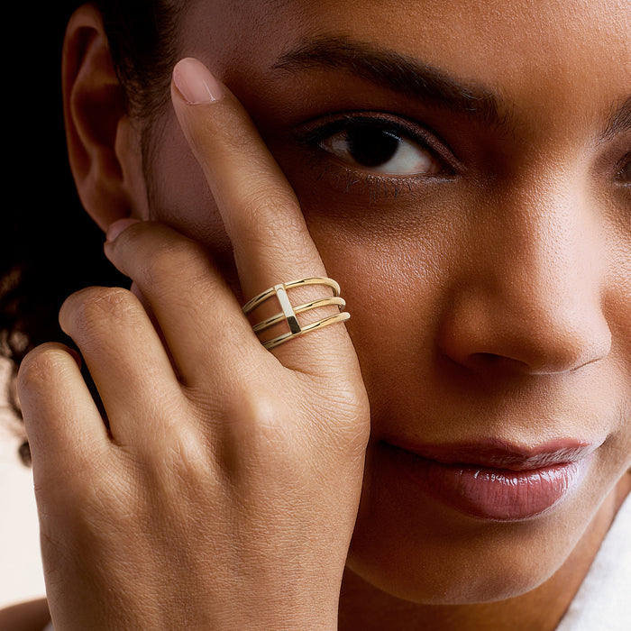 Yellow gold three-row bar ring on finger, raised central bar and stacked bands