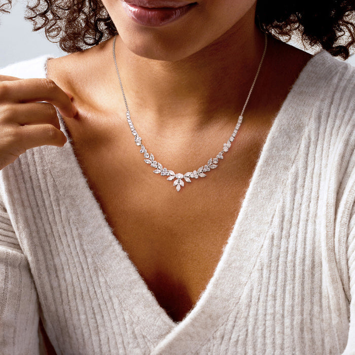 Rhodium-plated floral CZ necklace worn on neckline with center blossom and leaf links