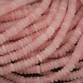Close-up of pink rose quartz beads on a black background
