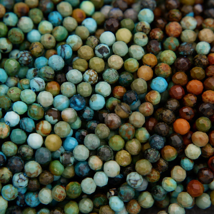 Close-up of multicolored beads in various shades of green, blue, and brown.